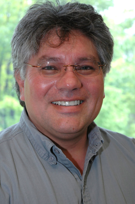 Photo of Prof. Richard Monette. He is wearing glasses and a gray button down and is smiling.