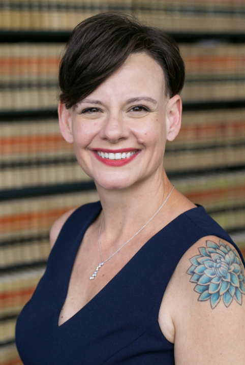 Image of Head of Reference & Scholarly Services Elizabeth Manriquez. She has short dark hair and is wearing a navy blue dress and smiling.